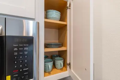 a cupboard with blue bowls and plates in it at Remote workers apartment or Long Stay Home