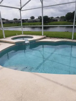 a large swimming pool in front of a lake at Lake Therapy by Paradise Resort Vacations in Orlando
