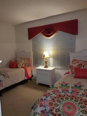 a bedroom with two beds and a window with a lamp at Sunset Bliss Escape by Paradise Resort Vacations in Kissimmee