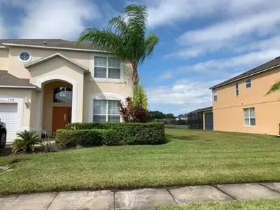 a house with a palm tree in the yard at Sunset Bliss Escape by Paradise Resort Vacations in Kissimmee
