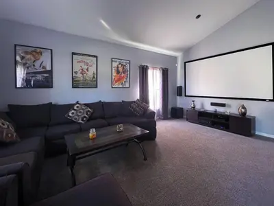 a living room with a couch and a large screen at Woodcrest Luxury by Paradise Resort Vacations in Orlando