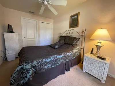a bedroom with a large bed and a lamp at Woodcrest Luxury by Paradise Resort Vacations in Orlando