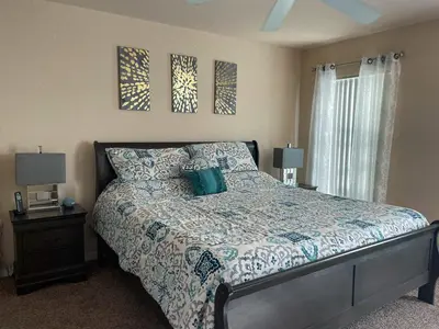 a bedroom with a bed and two pictures on the wall at Woodcrest Luxury by Paradise Resort Vacations in Orlando
