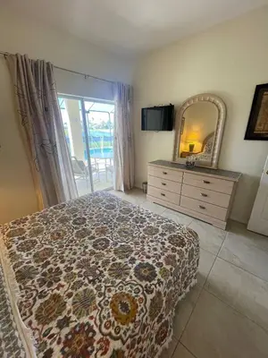 a bedroom with a bed and a mirror and a dresser at Ruby-rose Retreat in Kissimmee