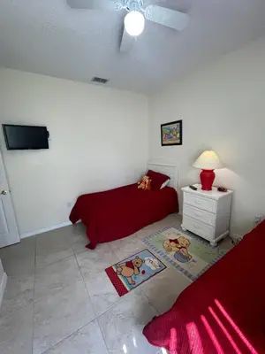 a bedroom with a bed and a tv on the wall at Ruby-rose Retreat in Kissimmee