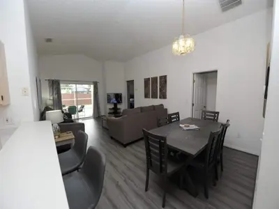 a dining room and living room with a table and chairs at Palmview Villa by Paradise Resort Vacations in Orlando