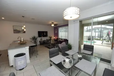 a kitchen and living room with a table and chairs at The Cove At East Storey Lake in Kissimmee
