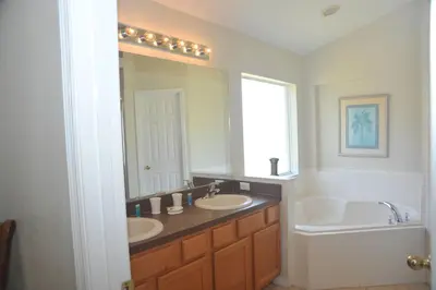 a bathroom with two sinks and a large mirror at Serenity Retreat Near Disney in Kissimmee