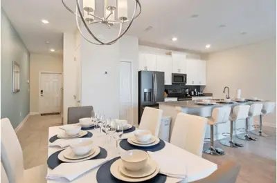 a dining room and kitchen with a table and chairs at Four-Bedroom Townhome Kissimmee in Orlando