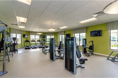 a gym with treadmills and elliptical machines at Four-Bedroom Townhome Kissimmee in Orlando