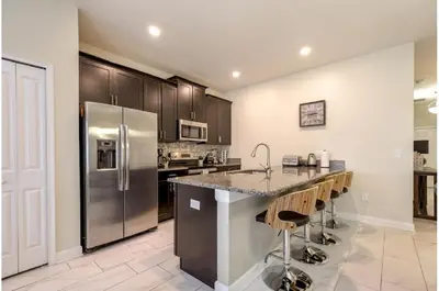 a kitchen with a stainless steel refrigerator and a counter at Four-Bedroom Townhome Kissimmee in Orlando