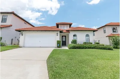 a large white house with a garage at Three-Bedroom Pool Home Kissimmee in Orlando