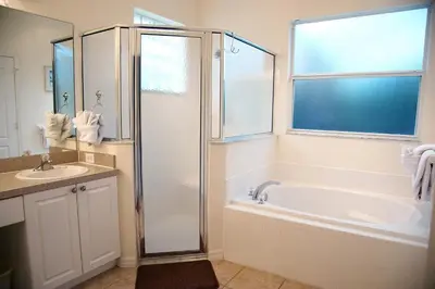 a bathroom with a shower and a tub and a sink at Four-Bedroom Pool Home Kissimmee in Orlando