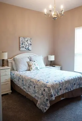 a bedroom with a bed and two night stands and a chandelier at Four-Bedroom Pool Home Kissimmee in Orlando