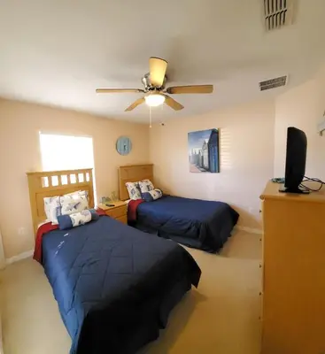 a bedroom with two beds and a ceiling fan at Four-Bedroom Pool Home Kissimmee in Orlando