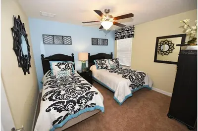 a bedroom with two beds and a ceiling fan at Five-Bedroom Pool Home Kissimmee in Orlando