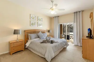a bedroom with a bed and a ceiling fan at Five-Bedroom Pool Home Kissimmee in Orlando