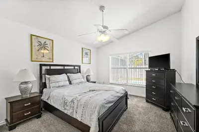 a bedroom with a bed and a flat screen tv at Near Disney Private Pool 4 Bedrooms in Kissimmee