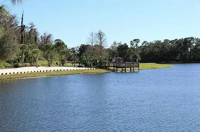 a lake with a dock in the middle of it at 4-Bed Home Near Disney Private Pool in Kissimmee