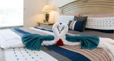 two swans made out of towels on a bed at DREAM Vacation BY A3G in Orlando