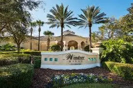 a sign in front of a house with palm trees at DREAM Vacation BY A3G in Orlando