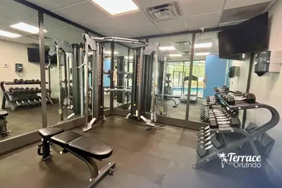 a gym with several tread machines and mirrors at Relaxing Central Condo with Balcony 7 Min to Universal in Orlando