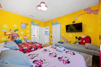 a bedroom with two beds and a yellow wall at 12BR Disney Home | Sleeps 30+, GameRoom, POOL/SPA! in Kissimmee