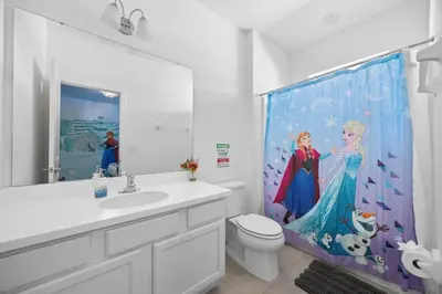 a bathroom with a disney princess shower curtain at 12BR Disney Home | Sleeps 30+, GameRoom, POOL/SPA! in Kissimmee