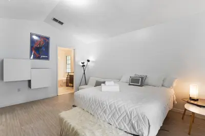 a white bedroom with a bed and a tv at 4BD Family Pool Home, Near Disney & Workspace in Orlando