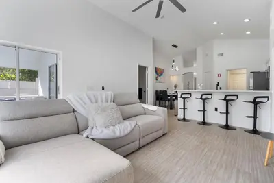 a living room with a couch and a kitchen at 4BD Family Pool Home, Near Disney & Workspace in Orlando
