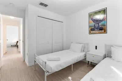 a white bedroom with two beds and a door at 4BD Family Pool Home, Near Disney & Workspace in Orlando