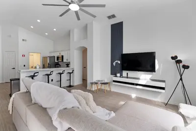 a living room with a couch and a flat screen tv at 4BD Family Pool Home, Near Disney & Workspace in Orlando