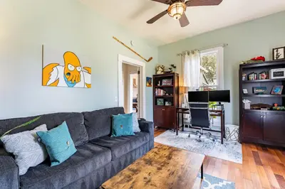 a living room with a gray couch and a television at Cozy 3BR Retreat - Near Bars Zoo & Lake Trails in Sanford