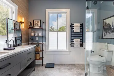 a bathroom with a sink and a toilet and a window at Cozy 3BR Retreat - Near Bars Zoo & Lake Trails in Sanford