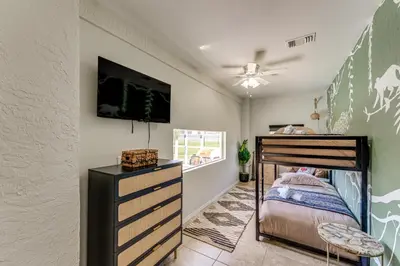 a bedroom with a bunk bed and a tv at Disney Getaway with Private Hot Tub 14 Mi to Parks in Kissimmee