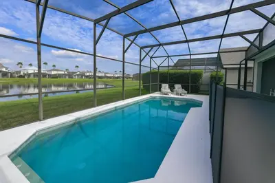 a swimming pool in a house with a glass roof at Casa 5 Quartos Vista Lago – Perto da Disney! in Kissimmee