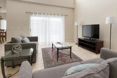 a living room with a couch and a flat screen tv at Casa 5 Quartos Vista Lago – Perto da Disney! in Kissimmee