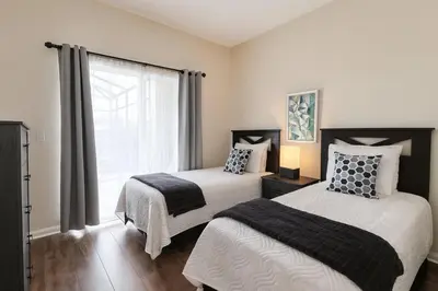 a bedroom with two beds and a window at Casa 5 Quartos Vista Lago – Perto da Disney! in Kissimmee