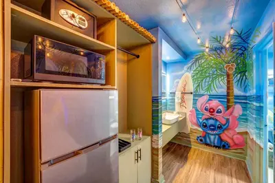 a kitchen with a painting on the wall at Surf and Sun Stitch Studio Kissimmee in Kissimmee