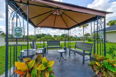 a gazebo with two benches and a table at Surf and Sun Stitch Studio Kissimmee in Kissimmee