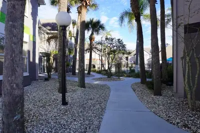 a sidewalk with palm trees and a street light at Condo Near Disney No Resort Fee Free Parking in Orlando