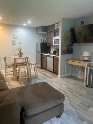 a living room with a couch and a table and a kitchen at Condo Near Disney No Resort Fee Free Parking in Orlando
