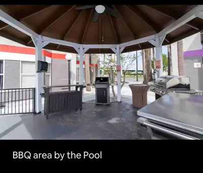 a bbq area by the pool with a pavilion at Condo Disney Universal Epic Free Parking in Orlando
