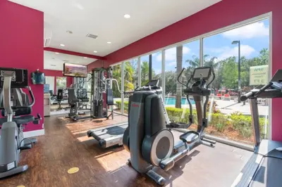 a gym with treadmills and ellipticals and a large window at Family 3BR near Disney -4102 in Kissimmee