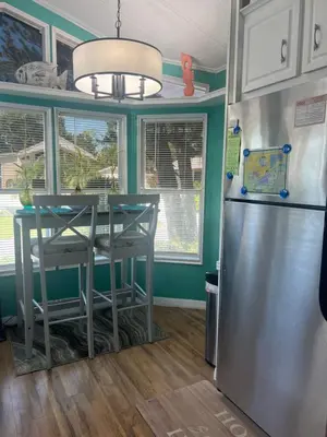 a kitchen with a table and a refrigerator at Cozy Private Cottage Only 5 miles from Disney in Kissimmee