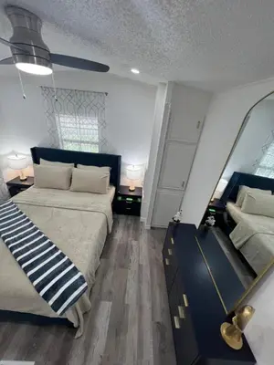 a bedroom with two beds and a large mirror at Luxury Tiny Cottage 5 miles from Disney in Kissimmee