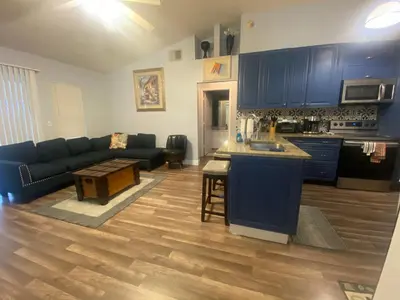 a living room with a blue couch and a kitchen at Orlando 4 bedroom Family Retreat in Orlando