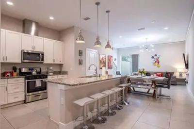 a large kitchen with a counter and a dining room at 4 Luxurious Suites Near Theme Parks and Downtown in Orlando