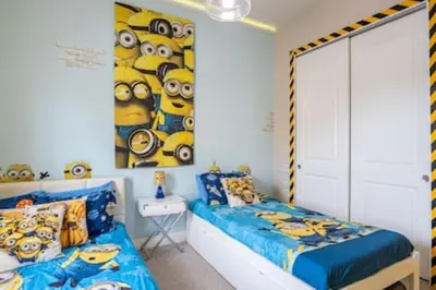a bedroom with two beds and a wall with minions at 4 Luxurious Suites Near Theme Parks and Downtown in Orlando