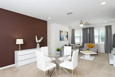 a living room with a glass table and white chairs at Luxuosa Villa 9 Suítes c/ Piscina Sonoma Resort in Kissimmee